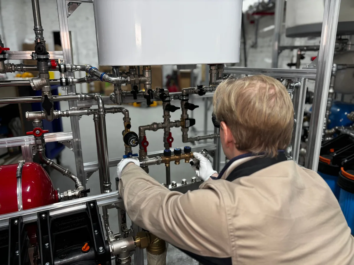 Plumber inspecting the valves and pipework on a hot water system