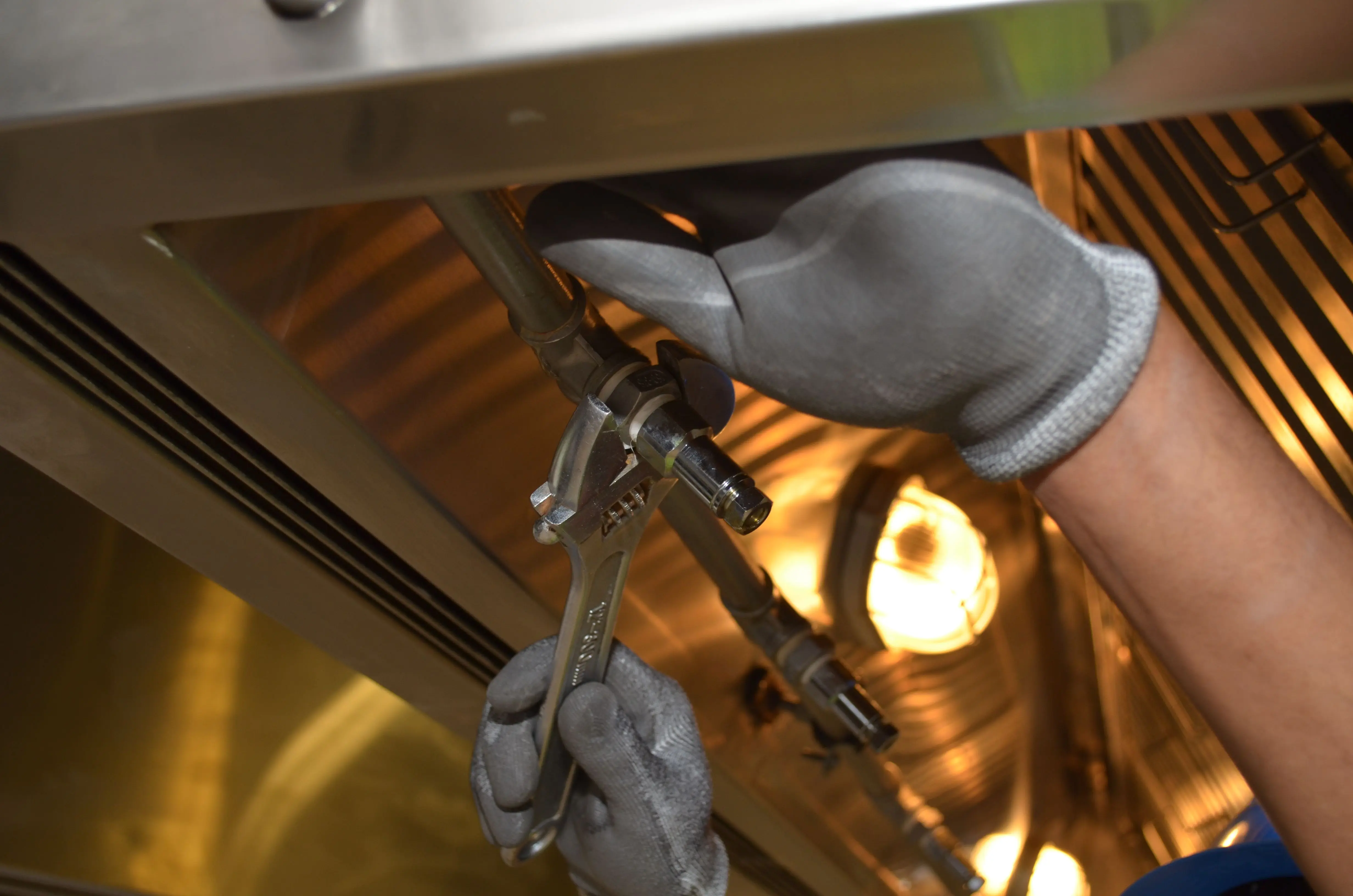 Plumber repairing a pipe under a kitchen sink